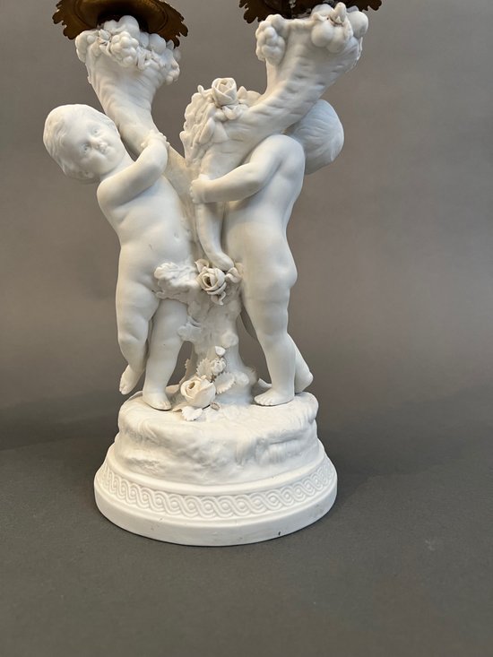 Coppia di candelieri in biscuit di Sévres con putti
