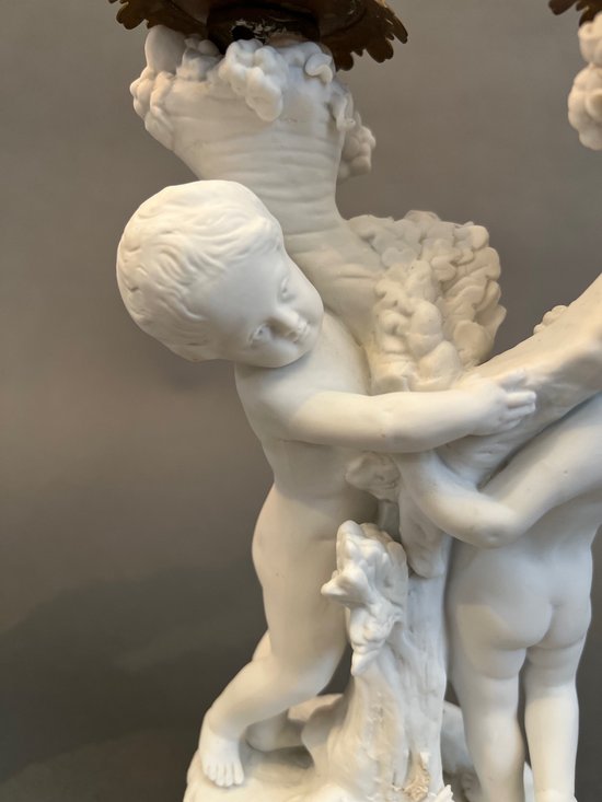 Coppia di candelieri in biscuit di Sévres con putti