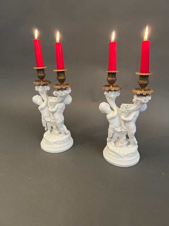 Coppia di candelieri in biscuit di Sévres con putti