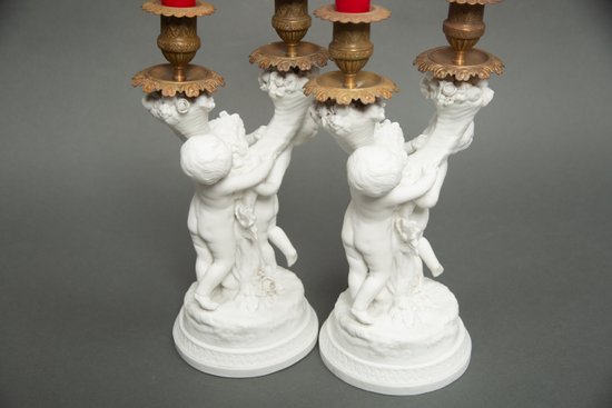 Coppia di candelieri in biscuit di Sévres con putti