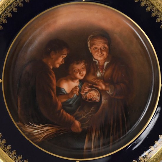 Plat en porcelaine de Limoges atelier de J. Balleroy décor peint famille se réchauffant atour d'un feu