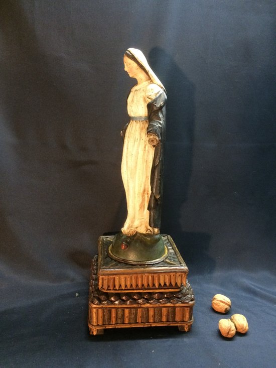 Vergine in legno intagliato su supporto in legno nero.