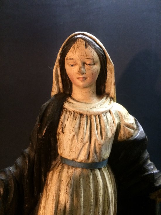 Vergine in legno intagliato su supporto in legno nero.