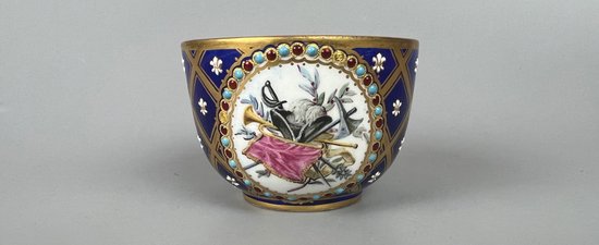 Raffinata coppa gioiello in stile Sèvres, dipinta con scene militari e trofei.