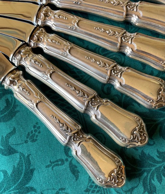 12 knives with silver handles.