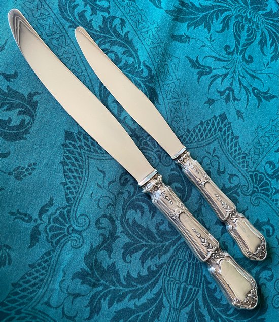12 knives with silver handles.