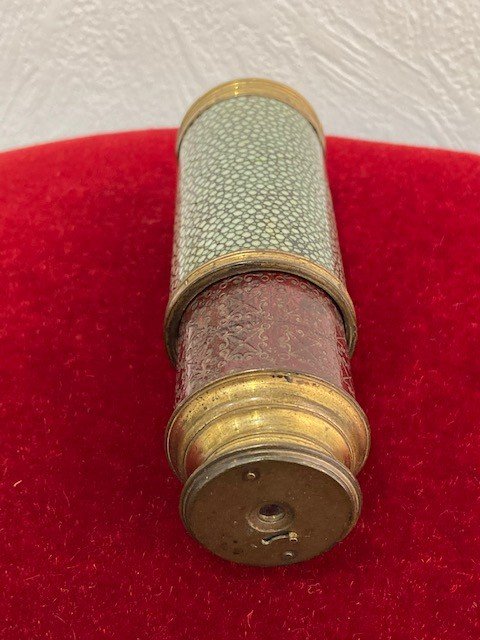 Lorgnette aus grün gefärbtem Rochenleder mit vergoldetem Messingring, an einem mit bordeauxrotem Leder umwickelten Rohr, signiert "Dollond London". XVIII. Jahrhundert