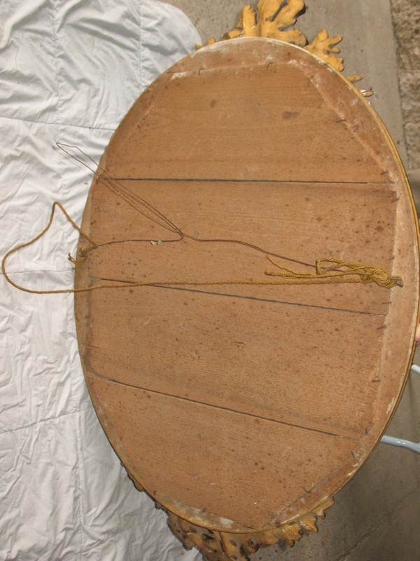 Carved oval mirror in wood and stucco gilded with leaf 19th century