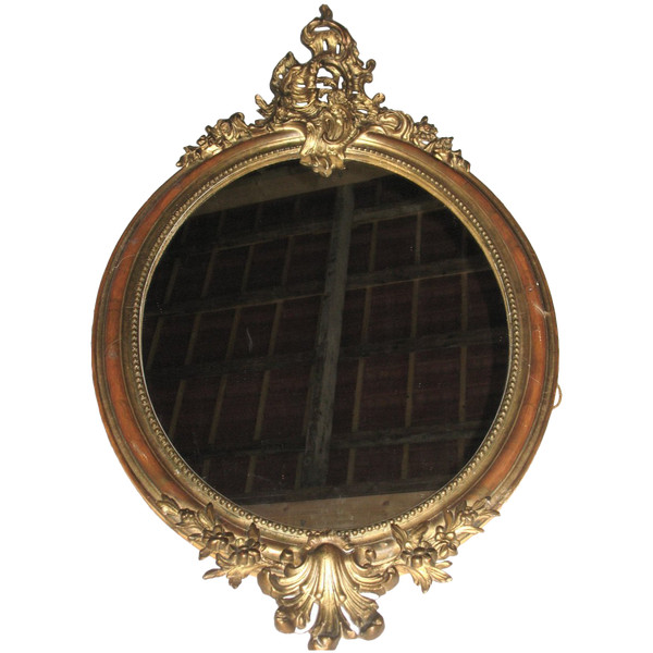 Carved oval mirror in wood and stucco gilded with leaf 19th century