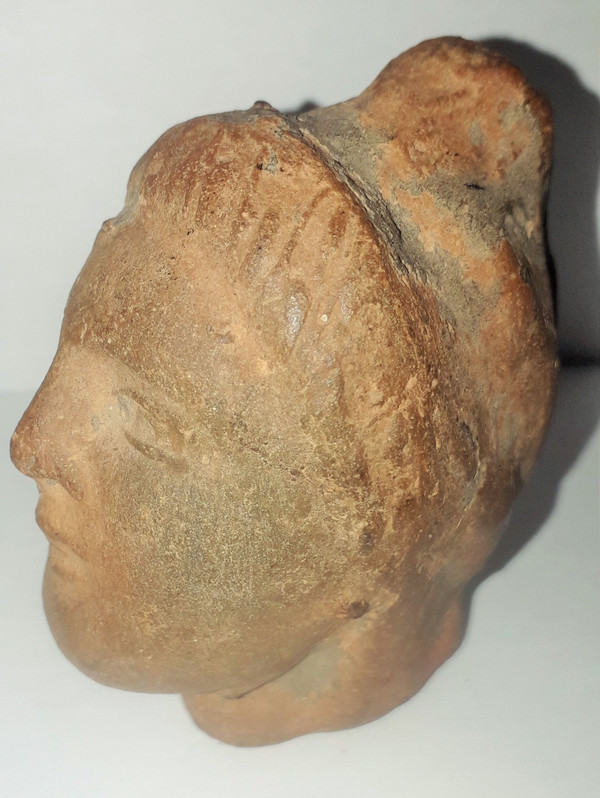 Antique head of a woman with a highlighted hairstyle raised in a high bun terracotta height 7.2 width 4 depth 5.5 cm
