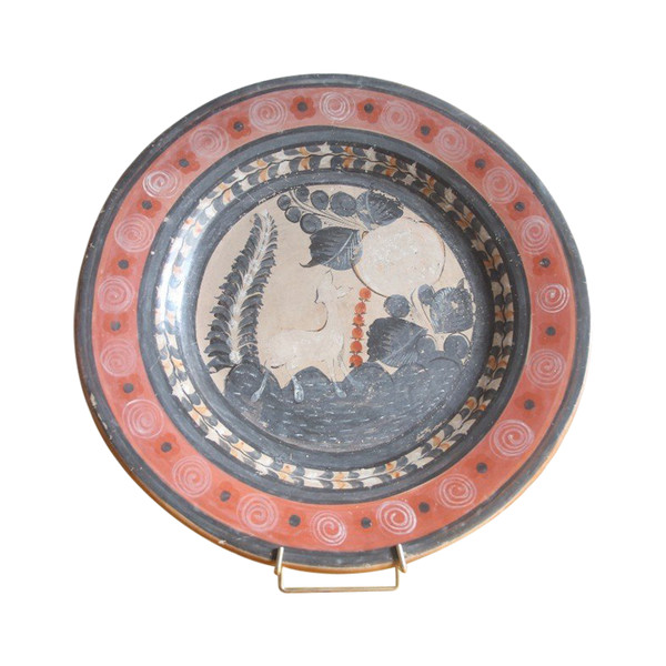 Grande piatto circolare in terracotta decorato con un cerbiatto in un paesaggio.
