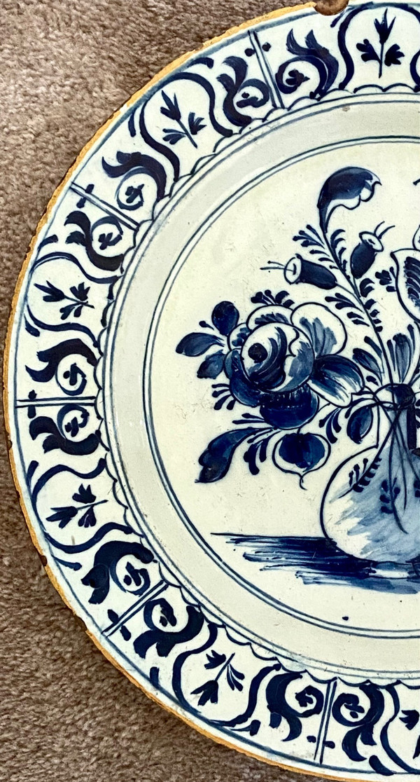 Delft, XVIII Secolo, Piatto Di Terracotta Decorato Con Vaso Bottiglia Fiorito.