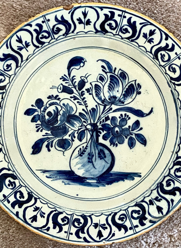Delft, XVIII Secolo, Piatto Di Terracotta Decorato Con Vaso Bottiglia Fiorito.