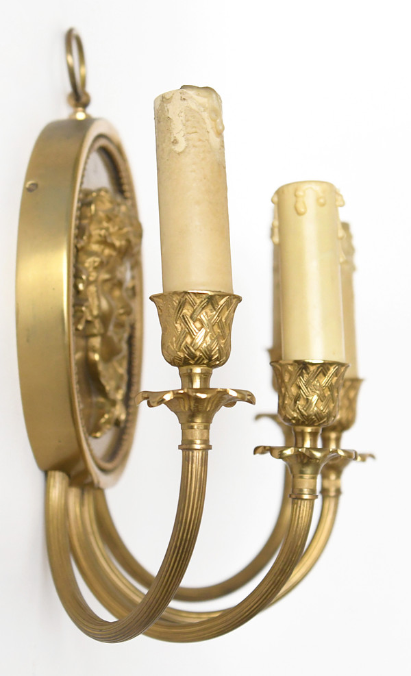 Pair of brass and gilded metal wall lights decorated with a Bacchus mask