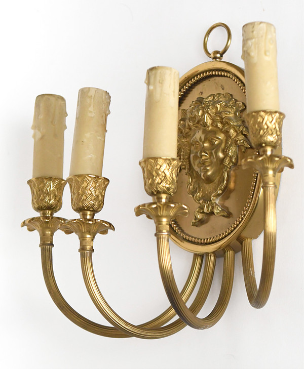 Pair of brass and gilded metal wall lights decorated with a Bacchus mask