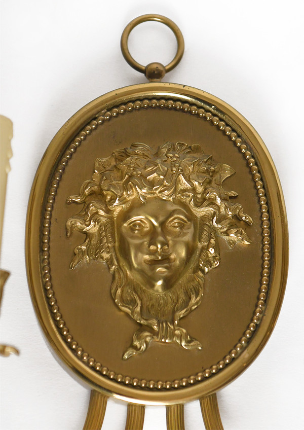 Pair of brass and gilded metal wall lights decorated with a Bacchus mask