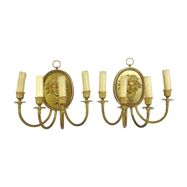 Pair of brass and gilded metal wall lights decorated with a Bacchus mask