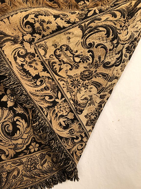 Antique tapestry or table cloth on a black background with rich decorations of Medici vases and flowers
