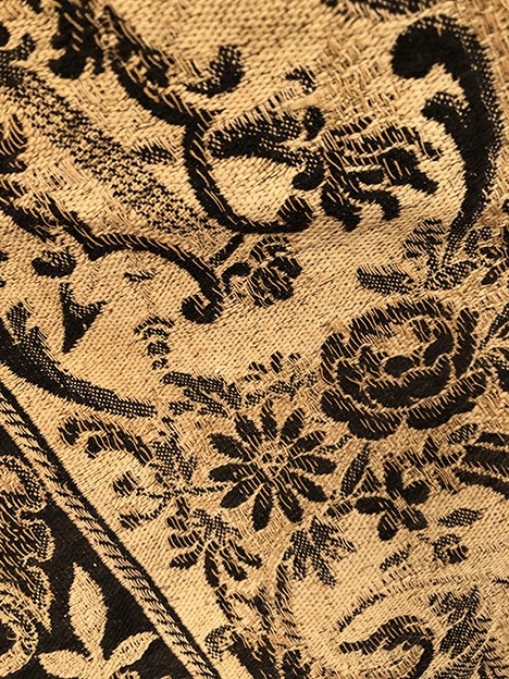 Antique tapestry or table cloth on a black background with rich decorations of Medici vases and flowers