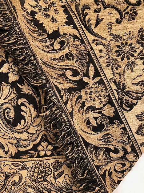 Antique tapestry or table cloth on a black background with rich decorations of Medici vases and flowers