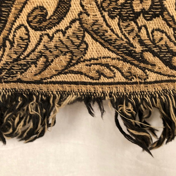Antique tapestry or table cloth on a black background with rich decorations of Medici vases and flowers