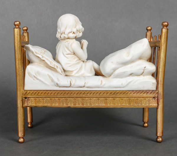 Miniatura a biscotto su letto in bronzo dorato. Fine XIX secolo