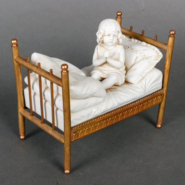 Miniatura a biscotto su letto in bronzo dorato. Fine XIX secolo