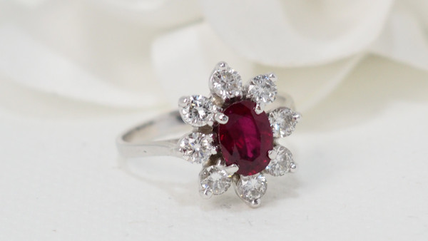 Surrounding ring in white gold, oval ruby and diamonds