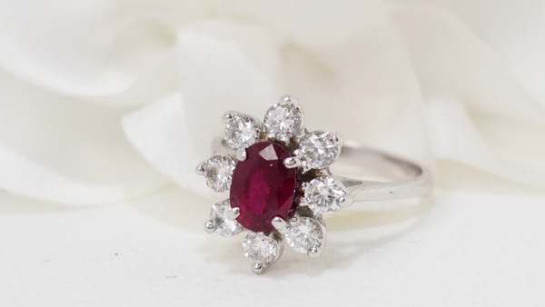 Surrounding ring in white gold, oval ruby and diamonds