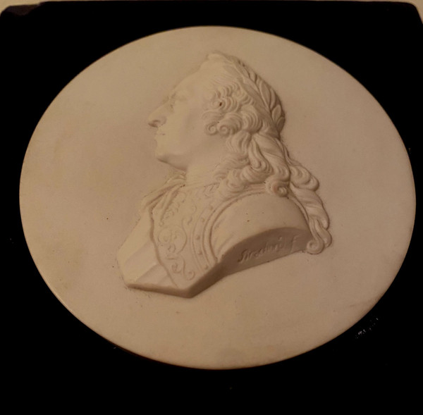 Die Medaille aus hartem Sèvres-Porzellan von König Ludwig XV. ist auf dem schwarzen Samtdisplay signiert