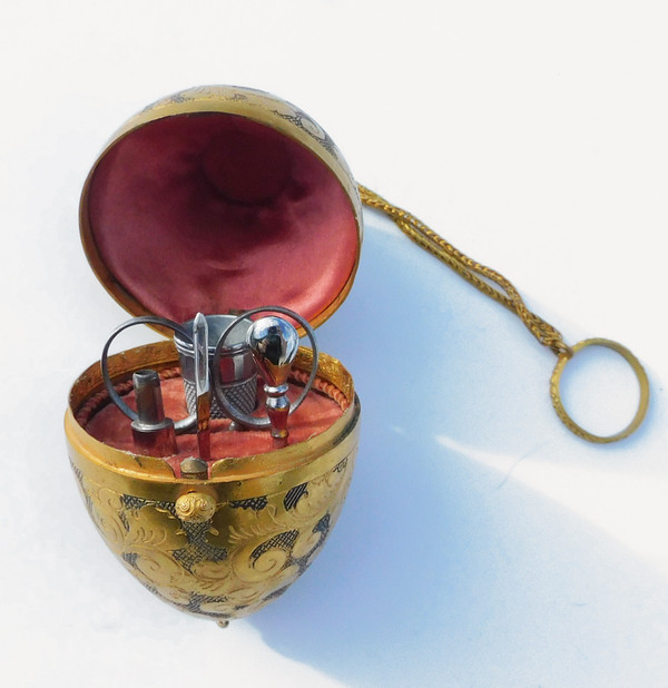 Miniature steel sewing kit in a golden metal egg-shaped box