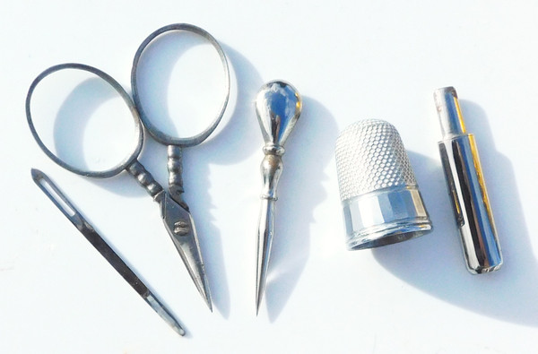 Miniature steel sewing kit in a golden metal egg-shaped box