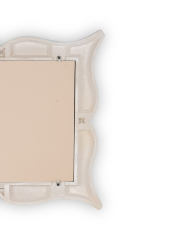 Art Deco style stucco mirror in “mustache” shape. 1990s.