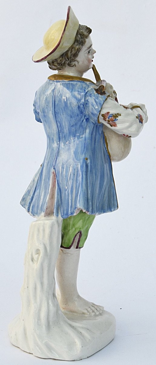 Statuette en porcelaine figurant un jeune garçon jouant de la cornemuse