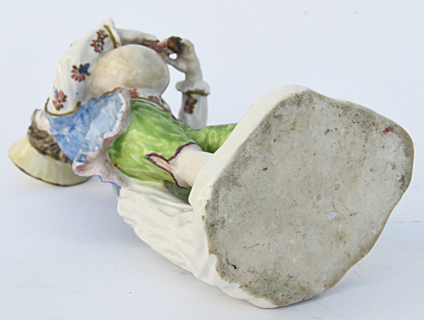 Statuette en porcelaine figurant un jeune garçon jouant de la cornemuse