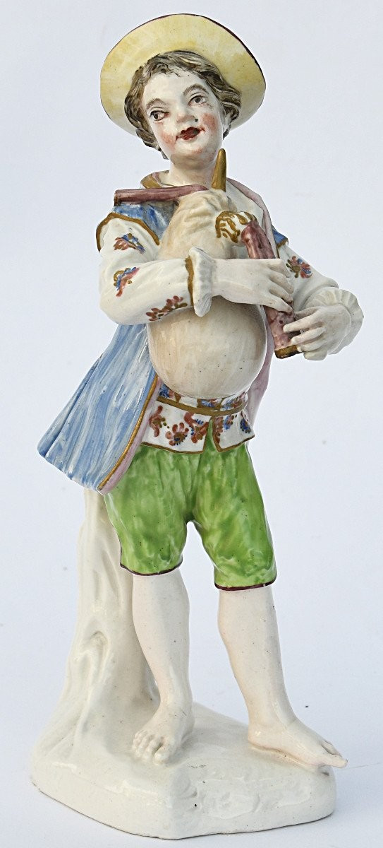 Statuette en porcelaine figurant un jeune garçon jouant de la cornemuse