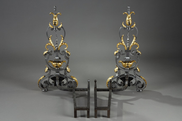 Paire de landiers en fer forgé à décor feuillagé, masque et volutes