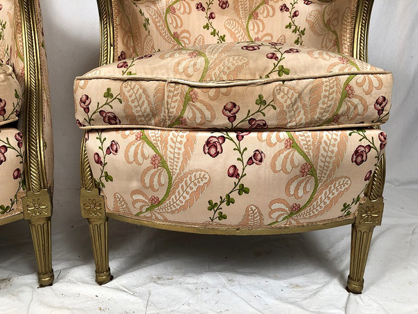 Paire de bergères en bois doré garnies de soie à motifs de fleurs, art déco d’inspiration Louis XVI