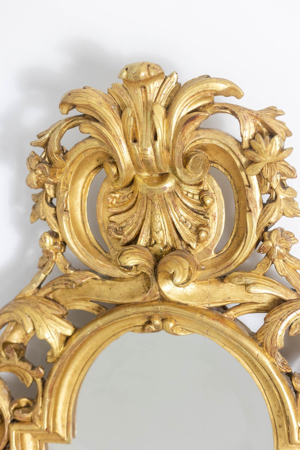 Miroir de style Régence en bois sculpté et doré. Années 1950.