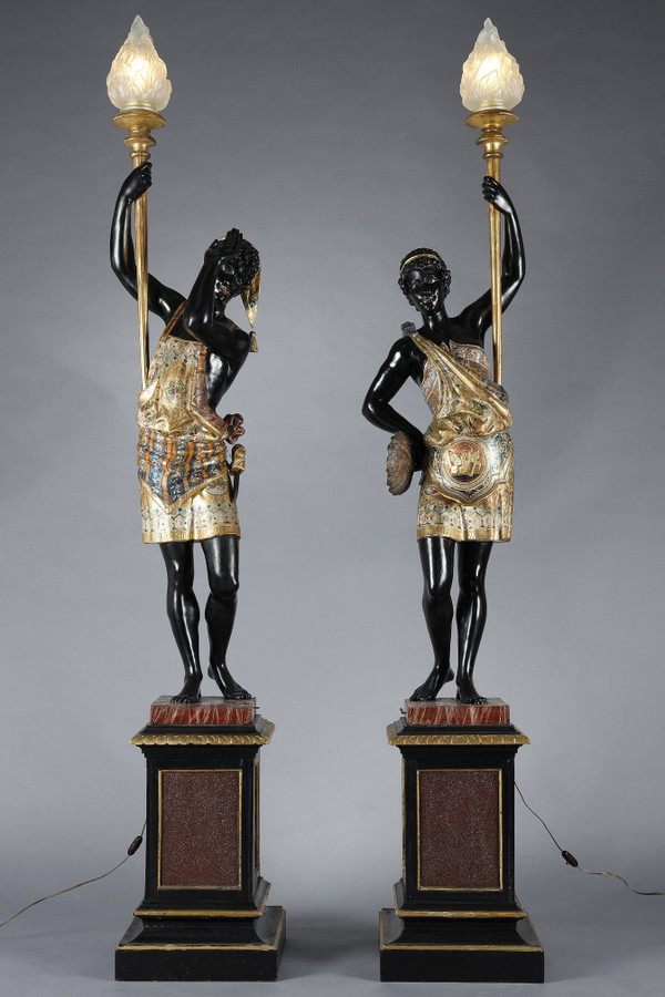 PAIR OF BLACK AND POLYCHROME LACQUERED WOOD TORCHHOLDERS DEPICTING NUBIANS