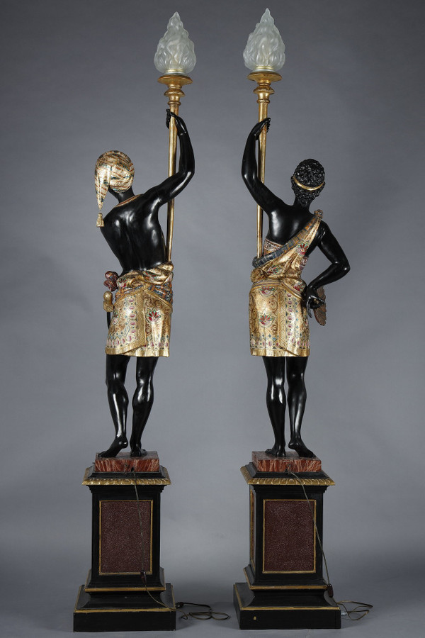 PAIR OF BLACK AND POLYCHROME LACQUERED WOOD TORCHHOLDERS DEPICTING NUBIANS