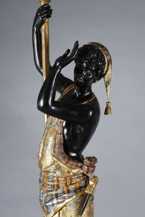 PAIR OF BLACK AND POLYCHROME LACQUERED WOOD TORCHHOLDERS DEPICTING NUBIANS