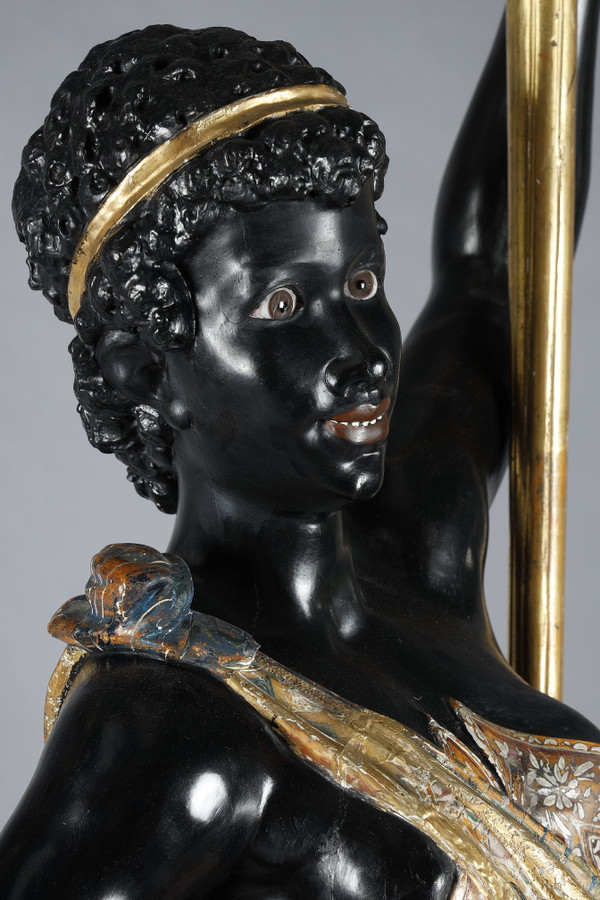PAIR OF BLACK AND POLYCHROME LACQUERED WOOD TORCHHOLDERS DEPICTING NUBIANS