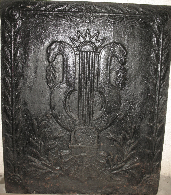 Large cast-iron fireback from the 18th century decorated with coat of arms and lyre