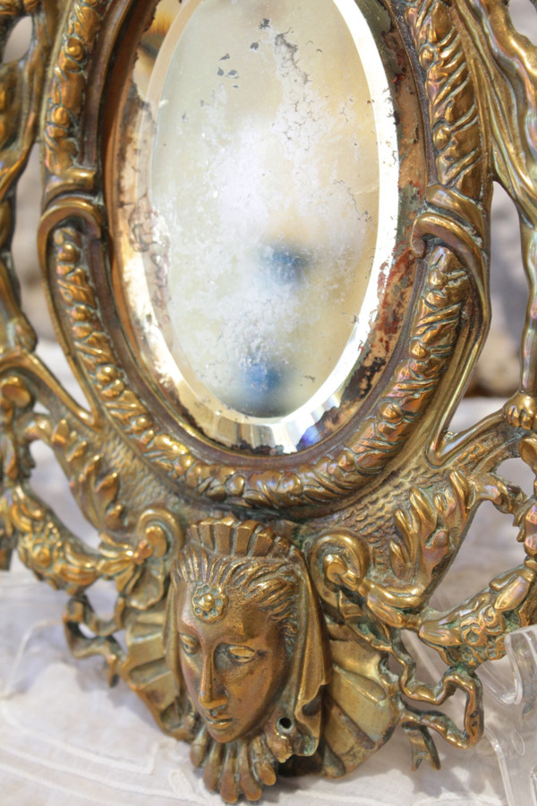 Specchio in bronzo decorato con putti e mascaroni fine XIX secolo