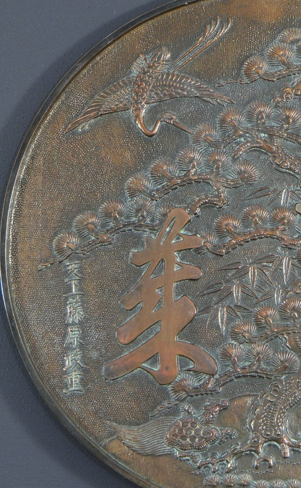 Giappone, XIX secolo, Specchio Kagami in bronzo argentato riccamente decorato con trampolieri.