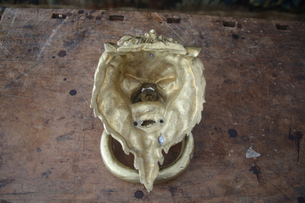 Battente in bronzo dorato con testa di leone, opera del XX secolo.