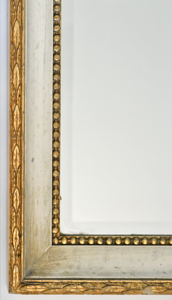 White and gold lacquered wood mirror with carved wooden pediment decorated with a basin