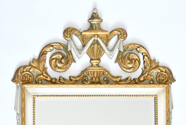 White and gold lacquered wood mirror with carved wooden pediment decorated with a basin