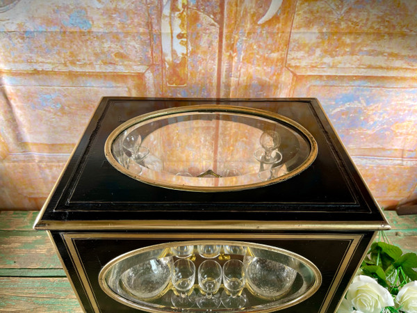 Napoleon III liqueur cellar in black wood, with brass fillets and chased glass portholes